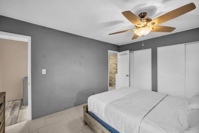 a bedroom with a large bed and a ceiling fan