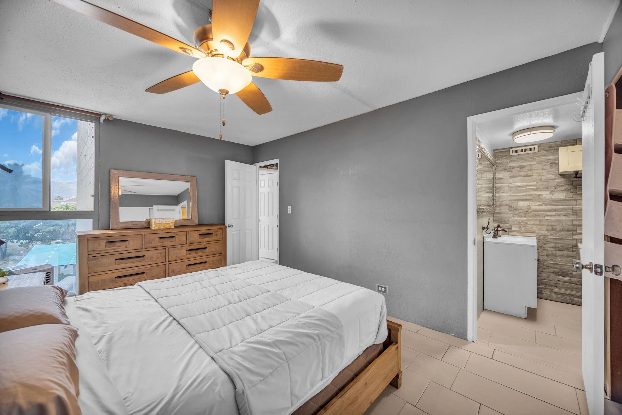 111 Kahului Beach Road, Unit D402 Kahului, HI 96732 - Photo 22 of 35 a bedroom with a large bed and a chandelier