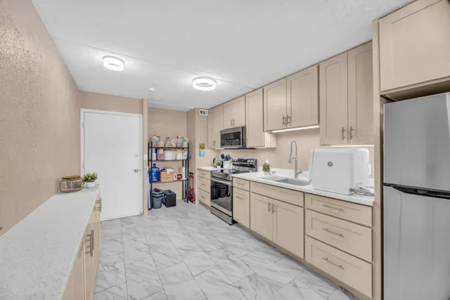 a kitchen with cabinets and a refrigerator