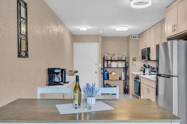 a kitchen with stainless steel appliances wooden floor and large refrigerator