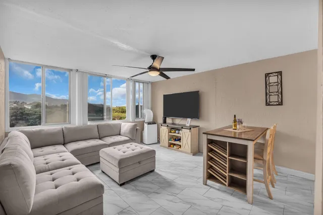 a living room with furniture a flat screen tv and a window