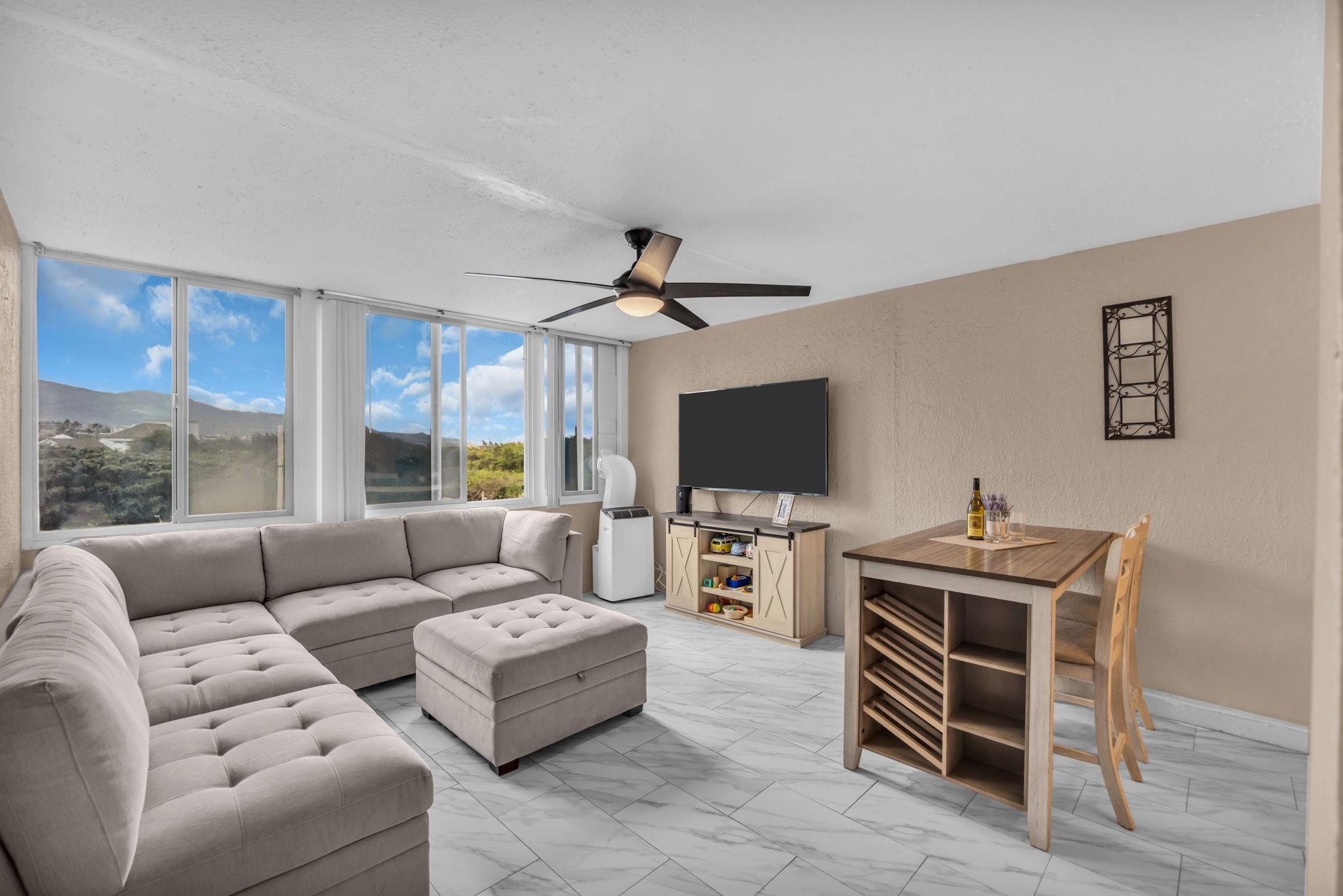 111 Kahului Beach Road, Unit D402 Kahului, HI 96732 - Photo 6 of 35 a living room with furniture a flat screen tv and a window