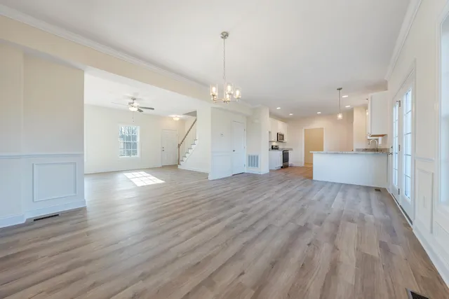 a view of a big room with wooden floor and windows