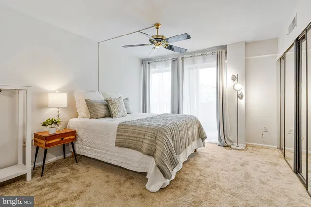 a spacious bedroom with a bed and a chandelier