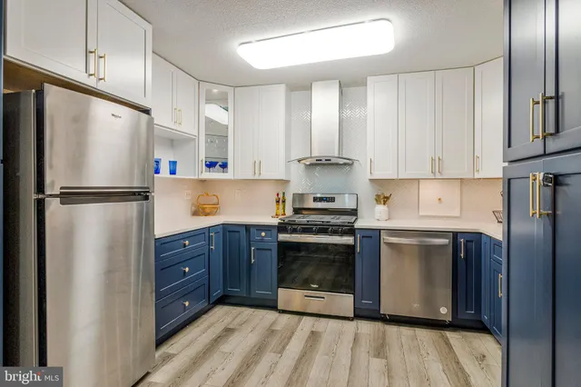 a kitchen with stainless steel appliances granite countertop a refrigerator and a stove top oven