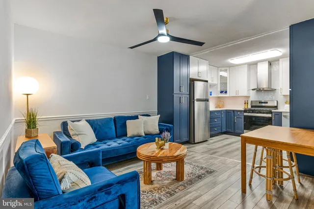 a living room with stainless steel appliances kitchen island granite countertop furniture and a refrigerator