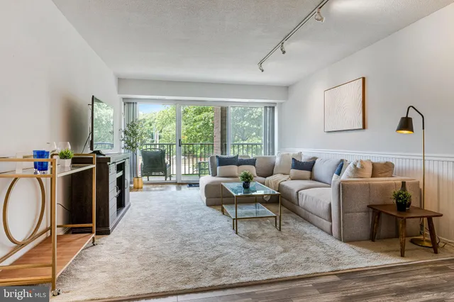 a living room with furniture a rug a fireplace and a large window