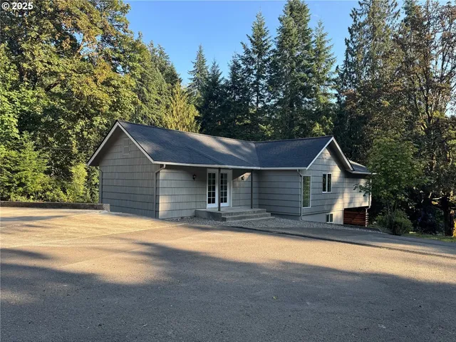 a front view of house with yard and trees in the background