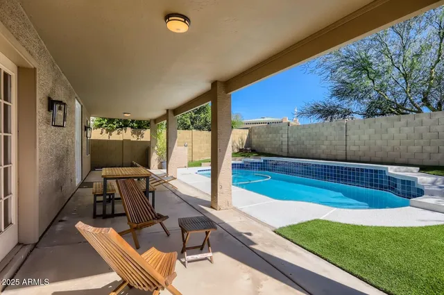 a view of a chairs and table in patio with a backyard