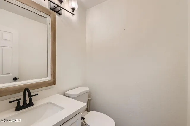 a bathroom with a sink a toilet and a mirror