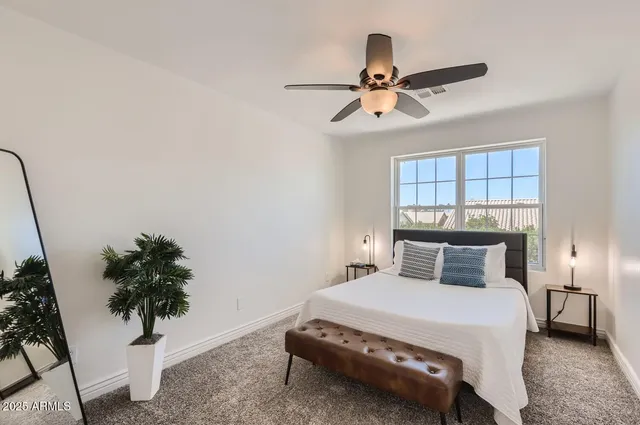a bedroom with a bed and a potted plant