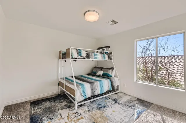 a bedroom with a bed and large windows