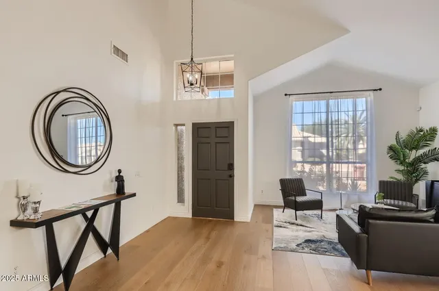 a living room with furniture a window and potted plants