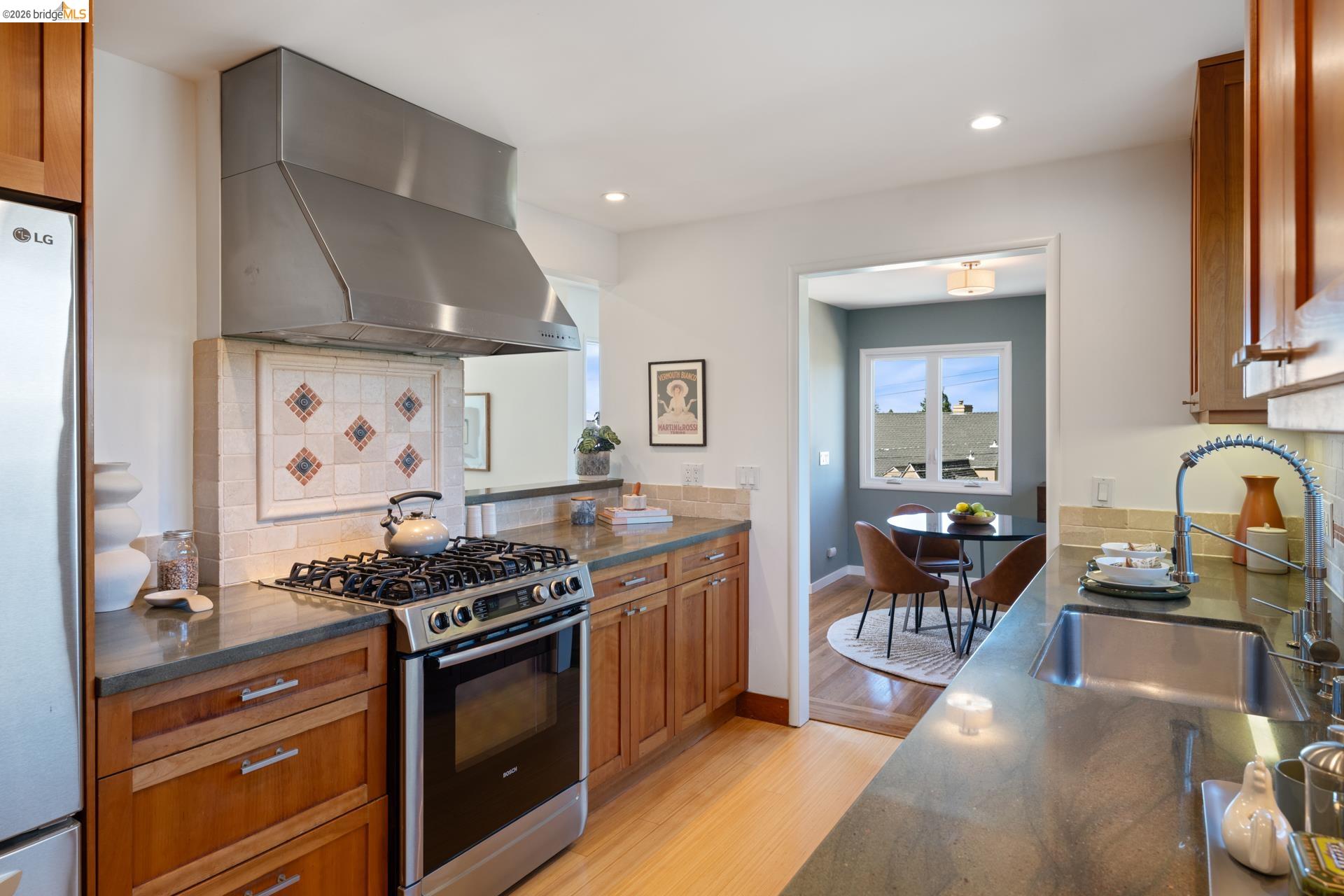 49 Windsor Avenue Kensington, CA 94708 - Photo 20 of 60 a kitchen with stainless steel appliances a stove a sink dishwasher and cabinets with wooden floor