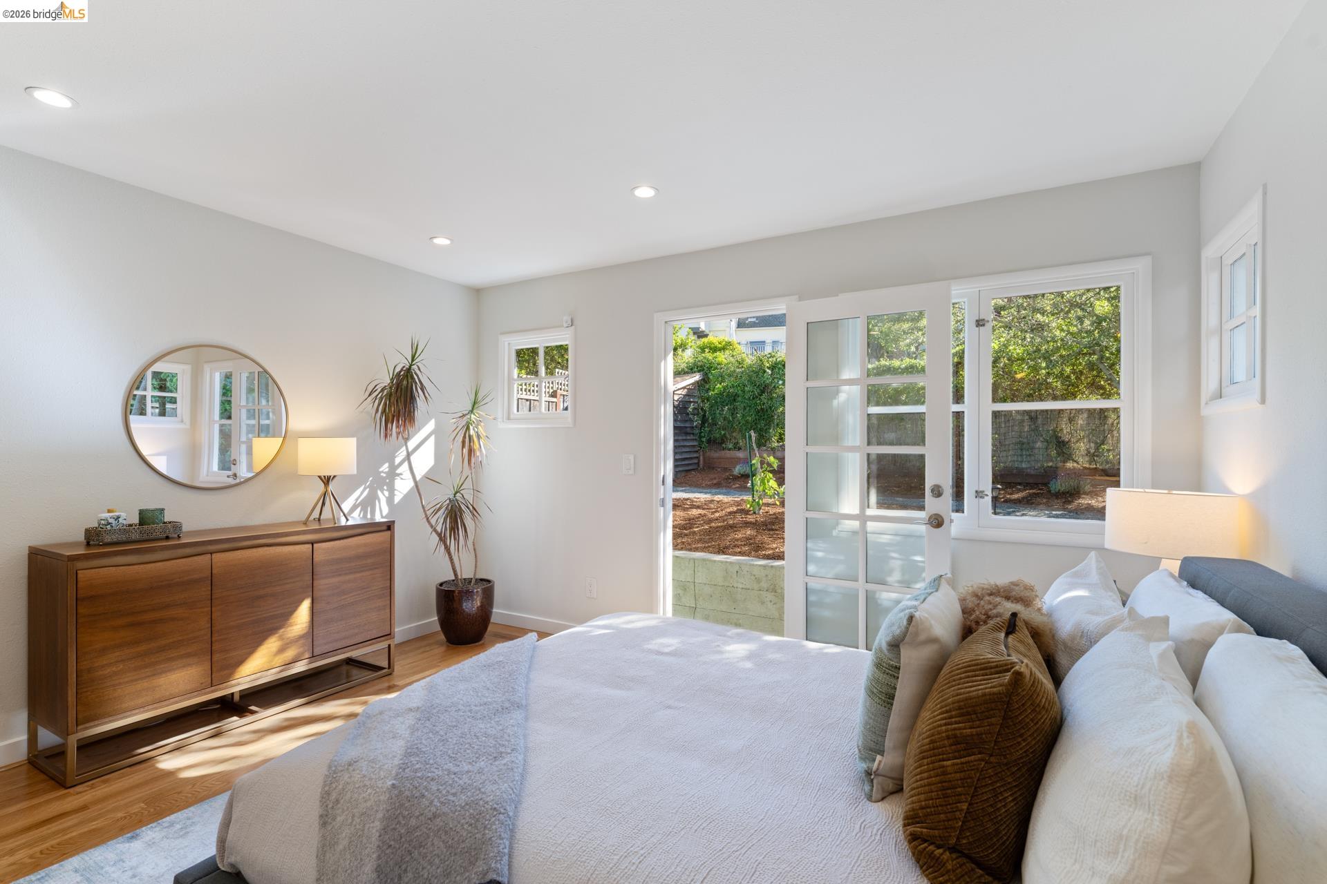 49 Windsor Avenue Kensington, CA 94708 - Photo 26 of 60 a bedroom with a bed a mirror and a large window with the garden view