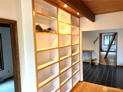 a view of a hallway with wooden floor and a glass door