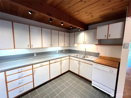 a kitchen with a refrigerator sink and cabinets