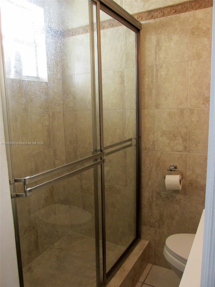 3030 Collins Avenue, Unit 3E Miami Beach, FL 33140 - Photo 11 of 20 a bathroom with a granite countertop shower and a toilet