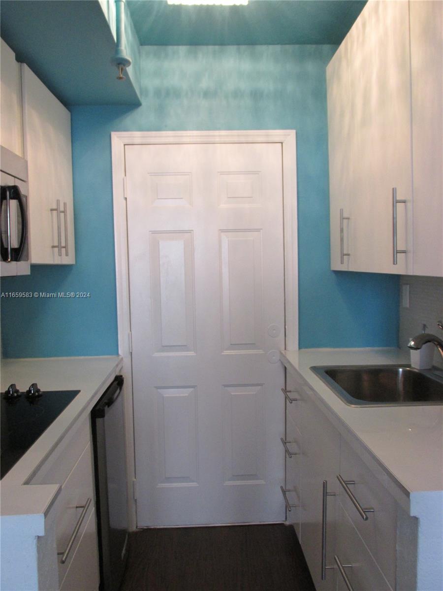 3030 Collins Avenue, Unit 3E Miami Beach, FL 33140 - Photo 4 of 20 a kitchen with a sink and cabinets