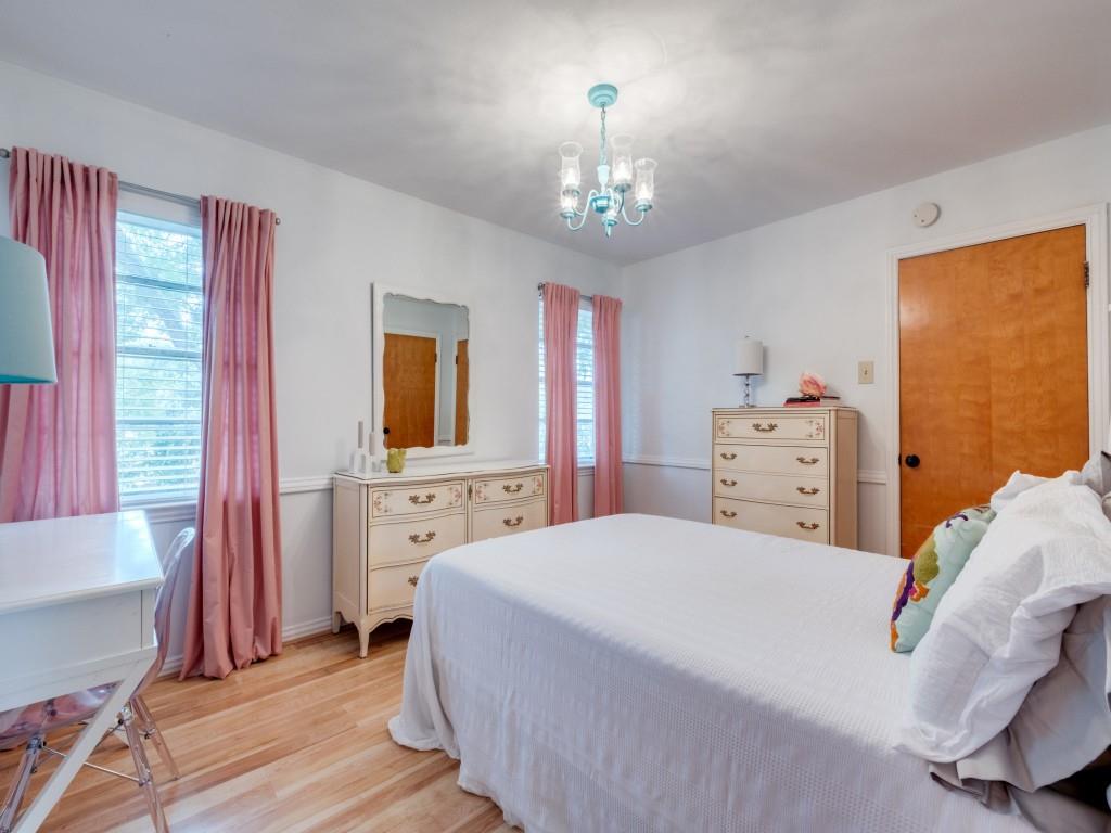 9753 Carnegie Drive Dallas, TX 75228 - Photo 19 of 25 a spacious bedroom with a bed and a chandelier