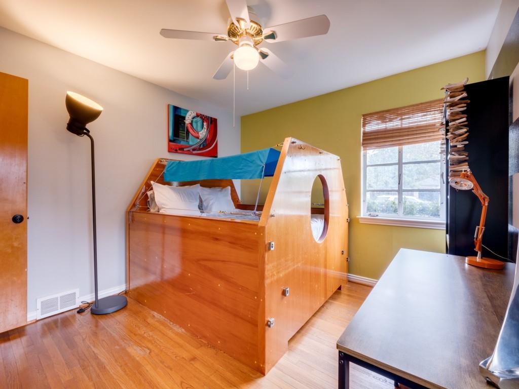 9753 Carnegie Drive Dallas, TX 75228 - Photo 20 of 25 a bedroom with a bed and a flat screen tv