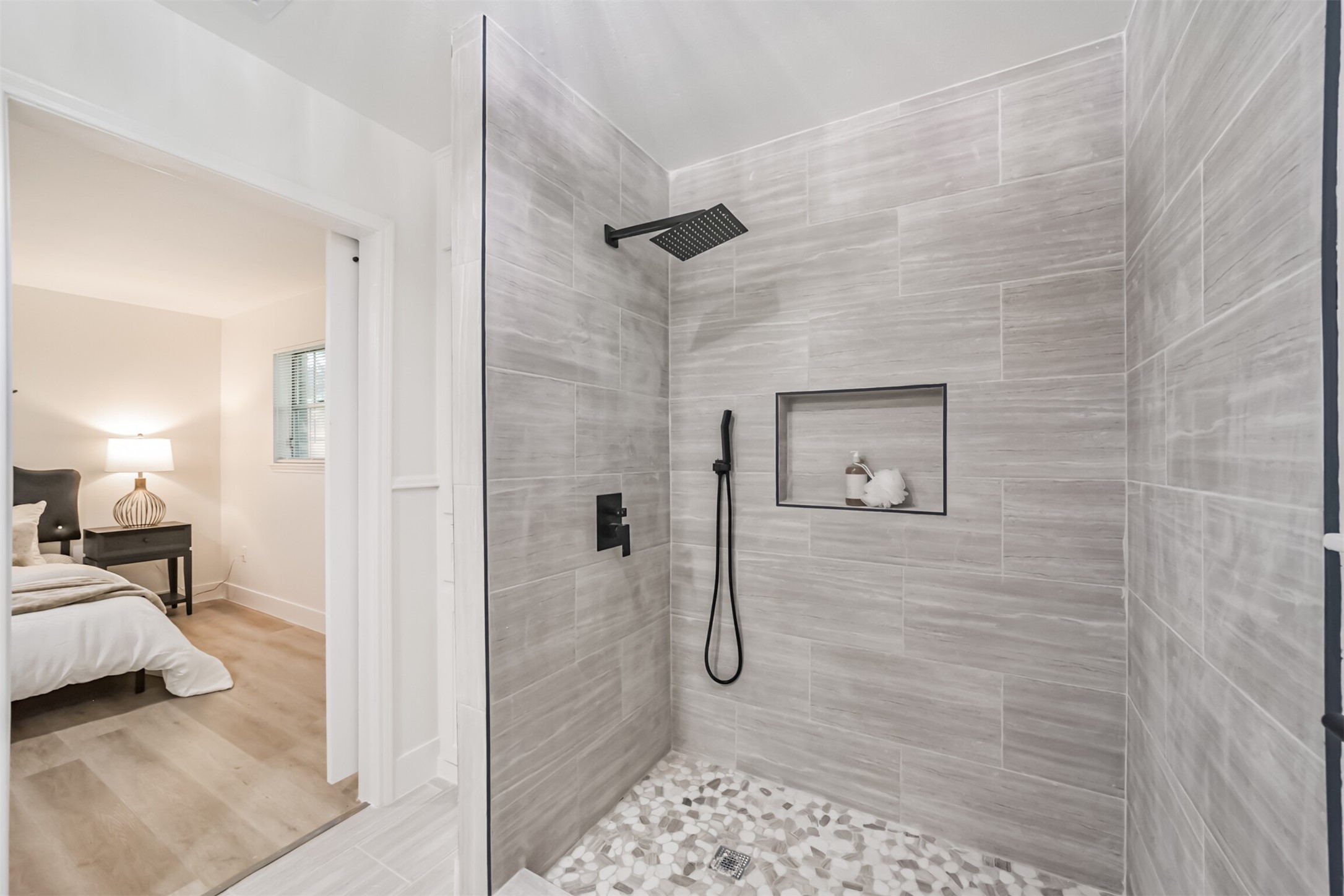 5403 Croix Road Manvel, TX 77578 - Photo 22 of 25 Primary shower featuring floor-to-ceiling tile, modern black fixtures, rainfall shower head and built-in niche.