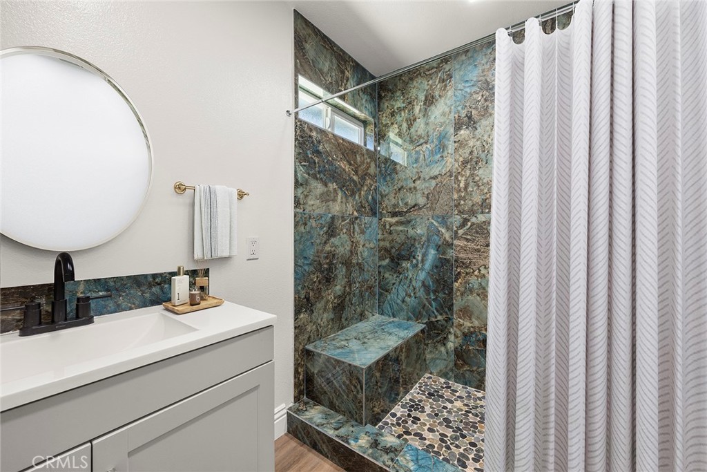 24582 Corta Cresta Drive Lake Forest, CA 92630 - Photo 18 of 26 a bathroom with a granite countertop sink a mirror and shower