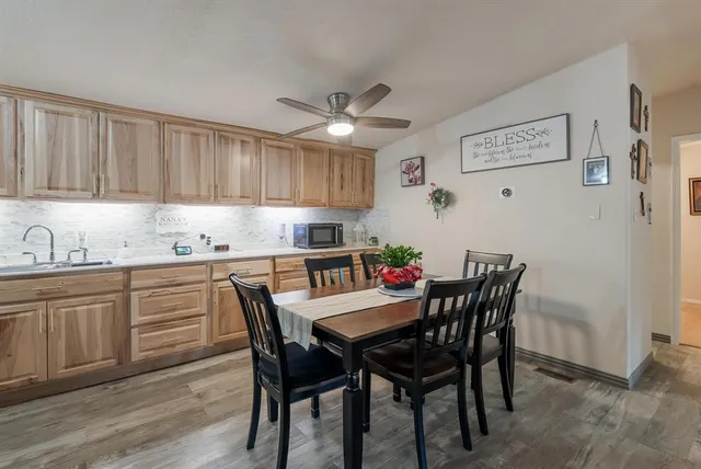 a kitchen with granite countertop a dining table chairs and white cabinets