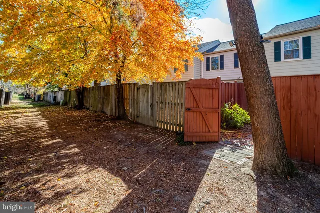 a view of a backyard with potted plants and wooden fence