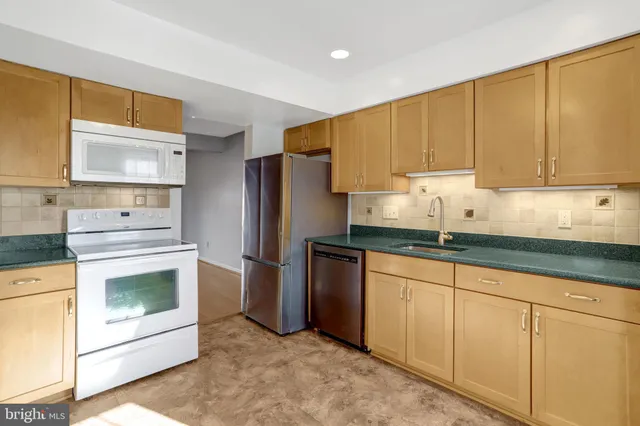 a kitchen with granite countertop white cabinets and stainless steel appliances