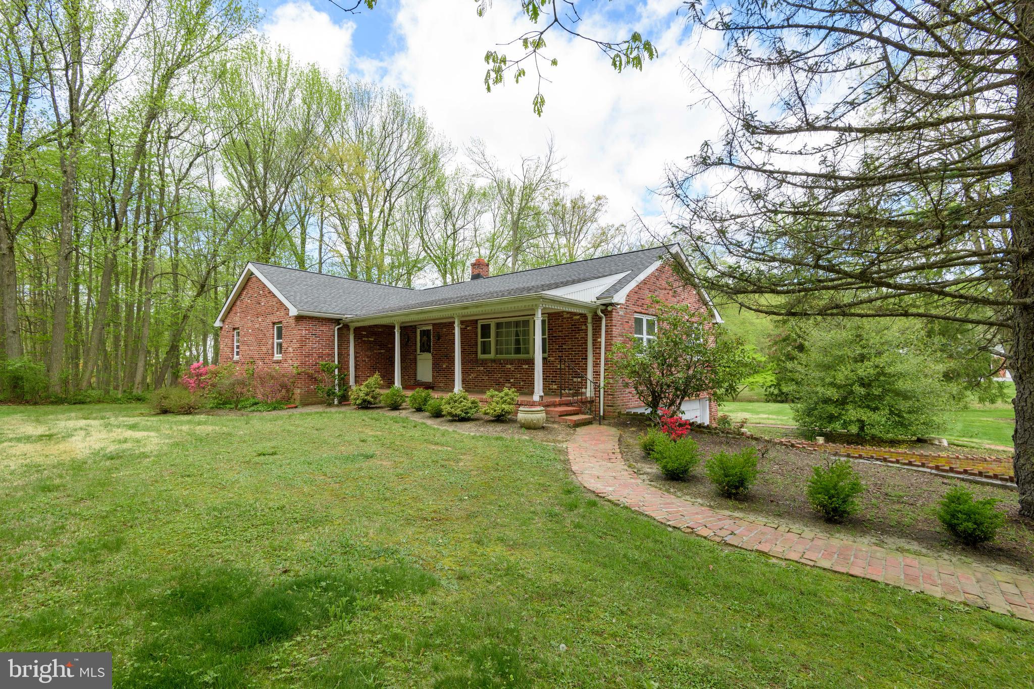 a front view of a house with a yard and trees