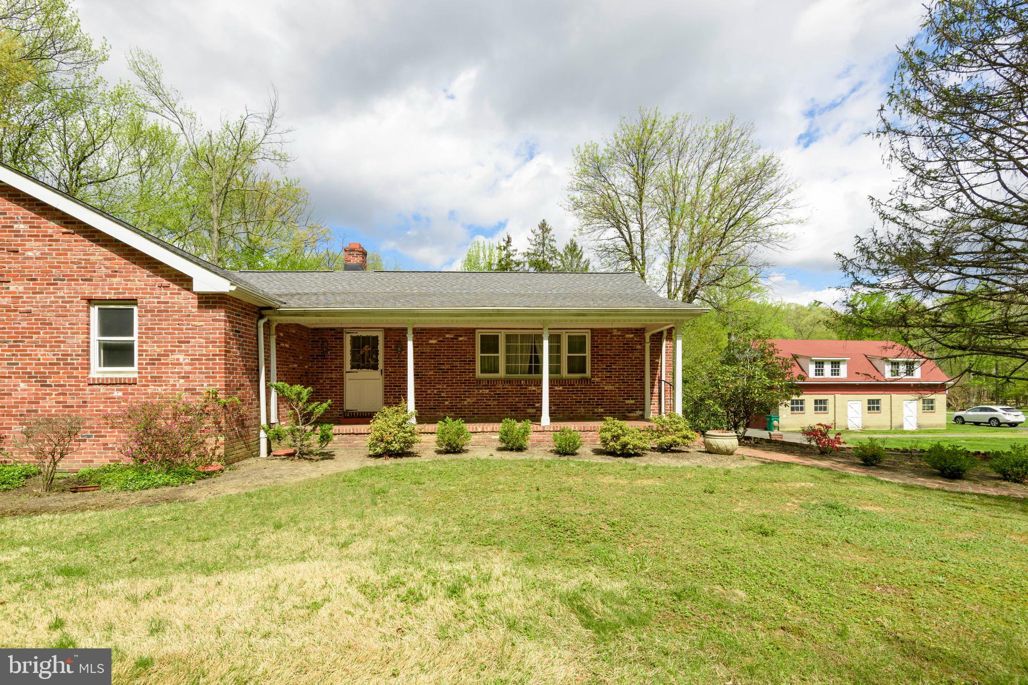 3463 Garnet Mine Road Garnet Valley, PA 19060 - Photo 3 of 38 a front view of a house with a garden and trees