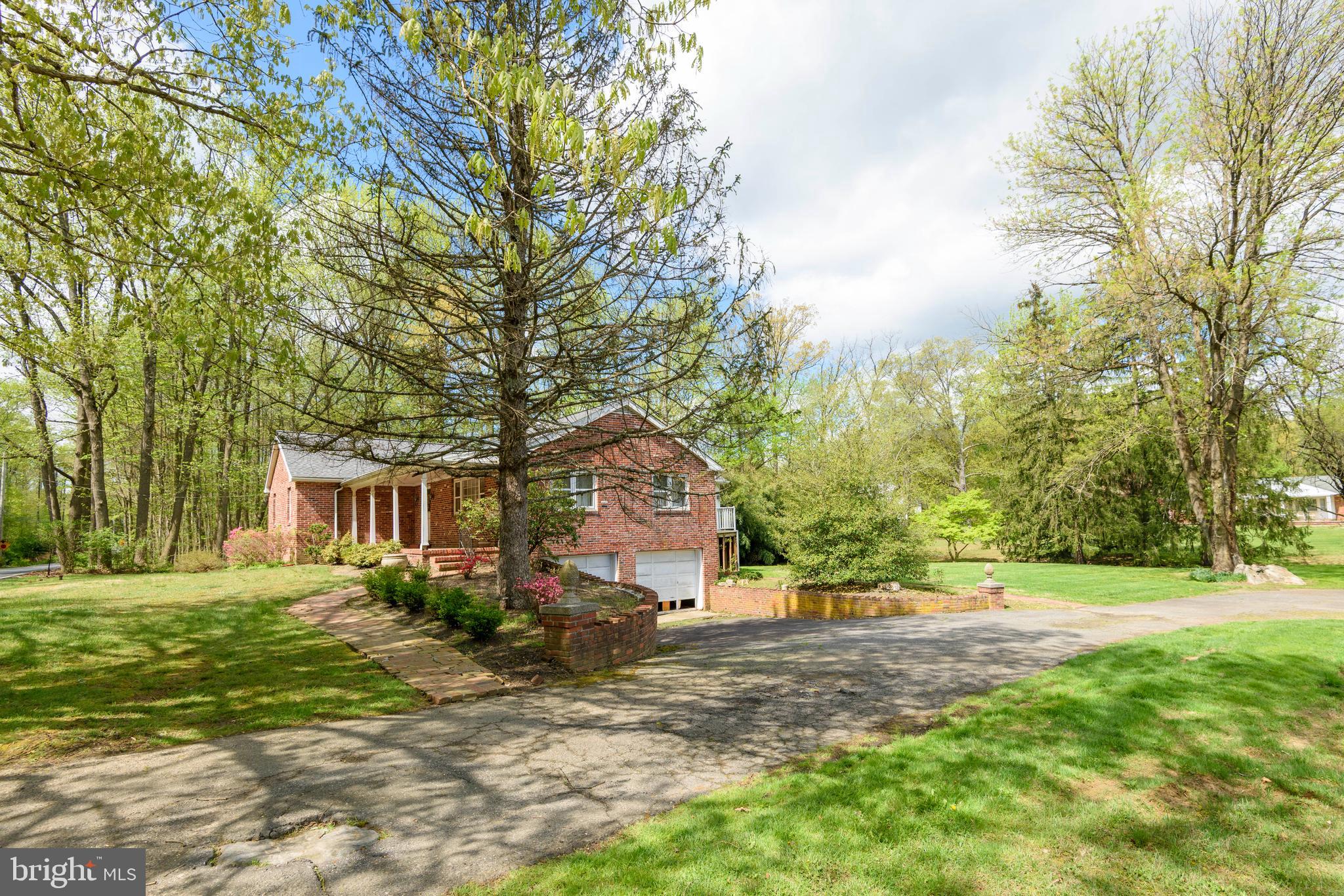 3463 Garnet Mine Road Garnet Valley, PA 19060 - Photo 4 of 38 a front view of a house with a yard and trees
