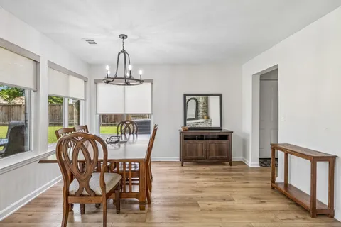 a dining room with furniture window and wooden floor