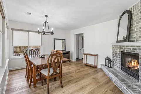 a dining room with furniture a chandelier and wooden floor