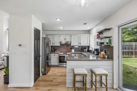 a kitchen with stainless steel appliances granite countertop a refrigerator and a stove top oven