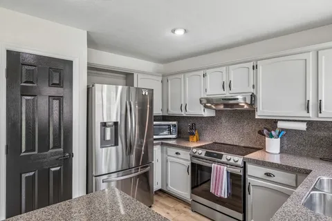 a kitchen with stainless steel appliances granite countertop a refrigerator stove and sink
