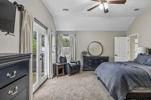a bed room with a bed a flat tv screen and a dresser