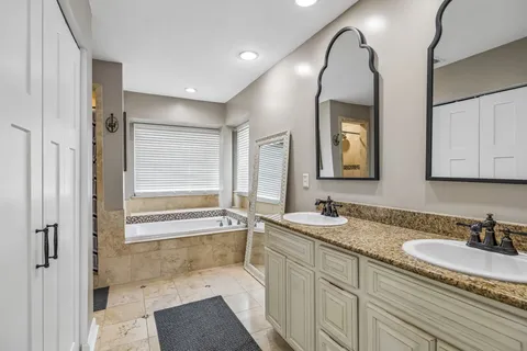 a bathroom with a granite countertop sink mirror bathtub and shower
