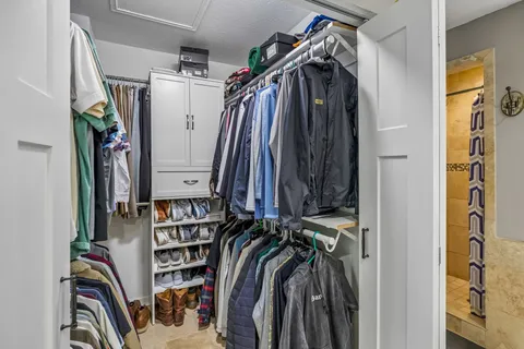 a view of walk in closet with clothes