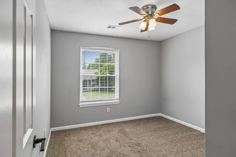 an empty room with closet and a window