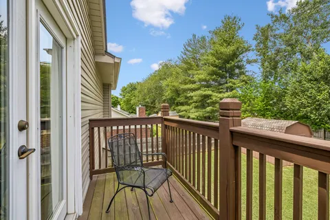 a view of balcony with wooden floor and fence