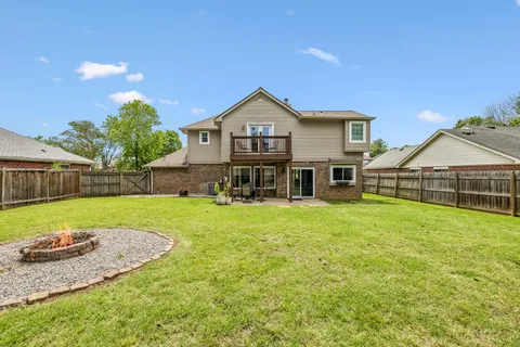 a view of backyard with small cabin and wooden fence