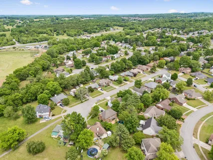 an aerial view of residential houses with outdoor space and trees