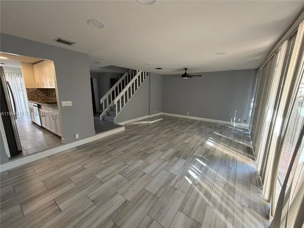a view of hallway with stairs and wooden floor
