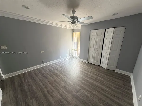a view of a livingroom with wooden floor and a ceiling fan