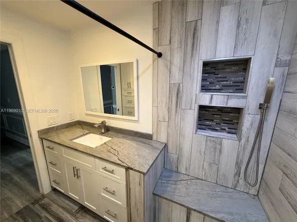 a bathroom with a granite countertop sink and a mirror