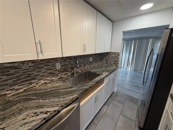 a kitchen with granite countertop a sink and a stove top oven