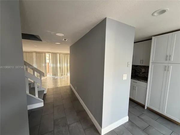 a view of hallway with furniture and a refrigerator