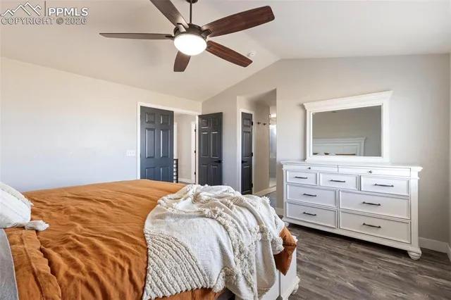 a bedroom with a bed and a mirror on the dresser